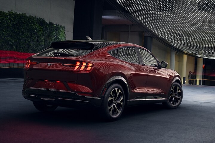 A rear view of the 2023 Ford Mustang Mach-E® at night under moody outdoor lighting