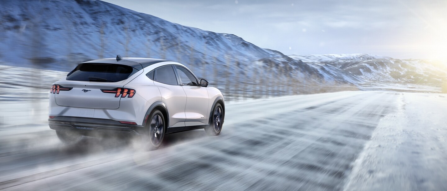 2023 Ford Mustang Mach-E® being driven on a windy, snowy road in the mountains