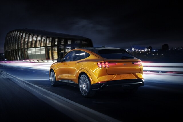 2023 Ford Mustang Mach-E® GT being driven at night near a stadium