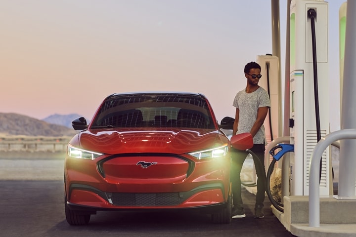 Man charging a 2023 Ford Mustang Mach-E® at a charging station