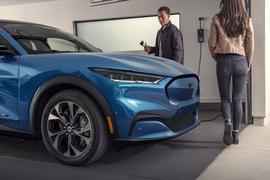 Una pareja cargando una Ford Mustang Mach-E® 2023 en un garaje
