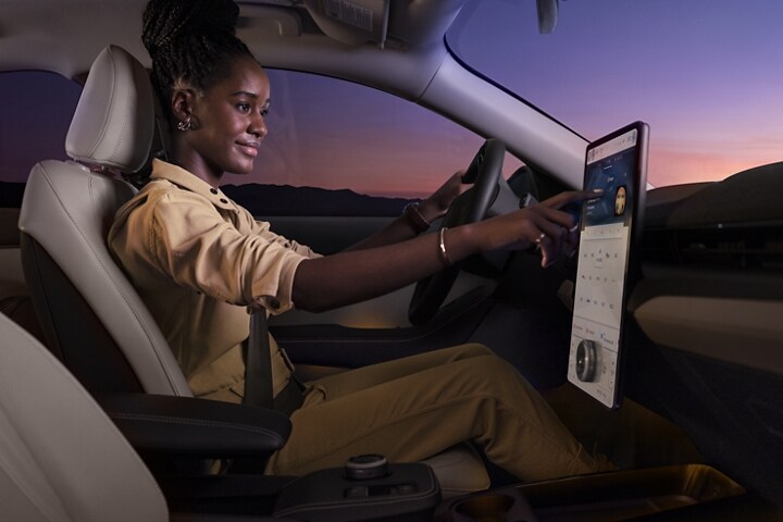 Mujer usando la pantalla táctil de 15.5” de una Ford Mustang Mach-E® 2023