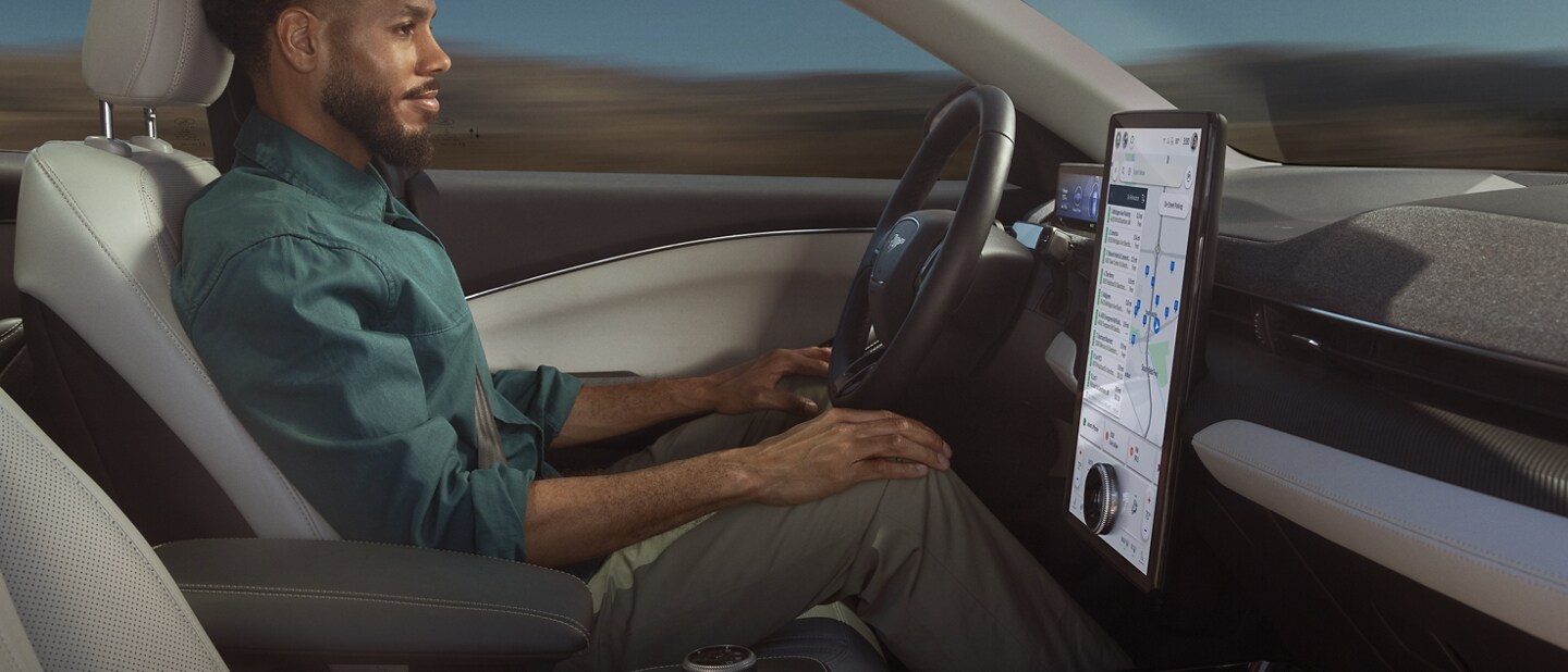 Man using Ford BlueCruise sitting in the driver’s seat of a 2023 Ford Mustang Mach-E® with hands on his knees