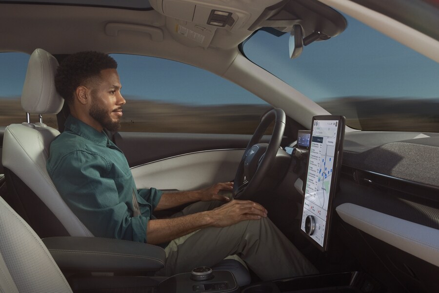 Man using Ford BlueCruise sitting in the driver’s seat of a 2023 Ford Mustang Mach-E® with hands on his knees