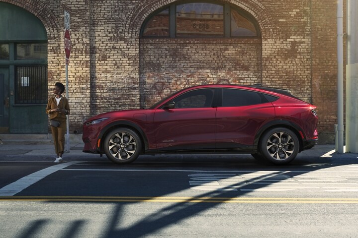Mujer parada frente a una Ford Mustang Mach-E® 2023 estacionada en la calle