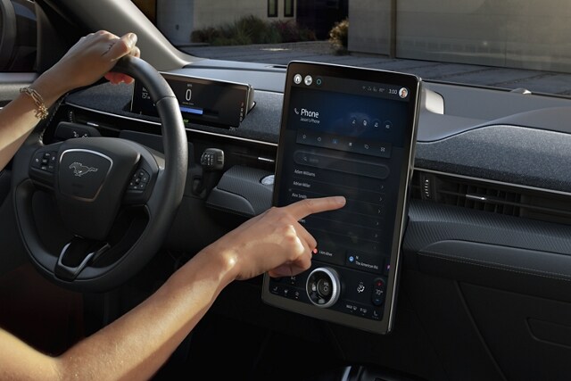 Person using the 15.5-inch portrait touchscreen in a 2023 Ford Mustang Mach-E®