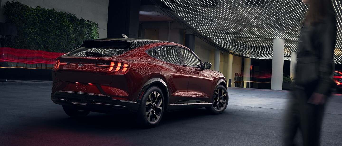 Vista 3/4 de una Ford Mustang Mach-E® 2023 estacionada bajo luces tenues al aire libre