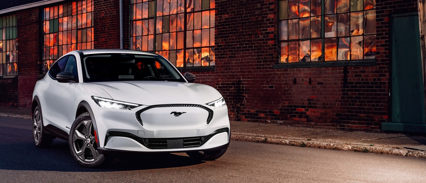 2023 Ford Mustang Mach-E® SUV parked outside a warehouse at dusk