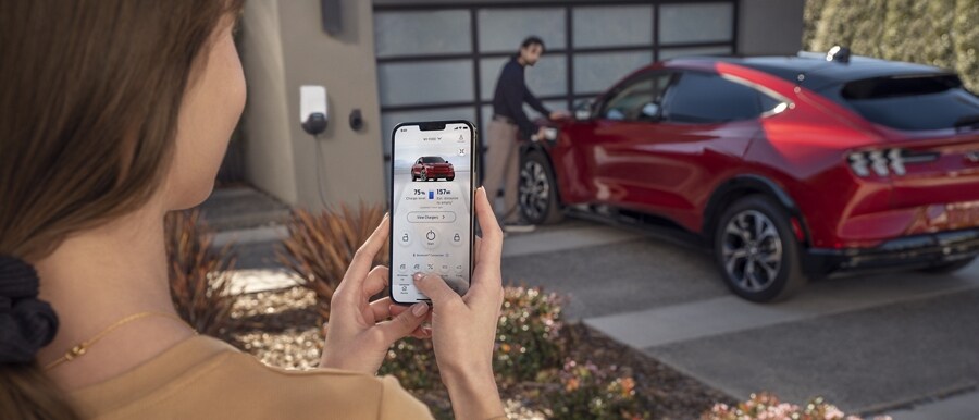 Woman using the FordPass App to remotely control her 2023 Ford Mustang Mach-E®