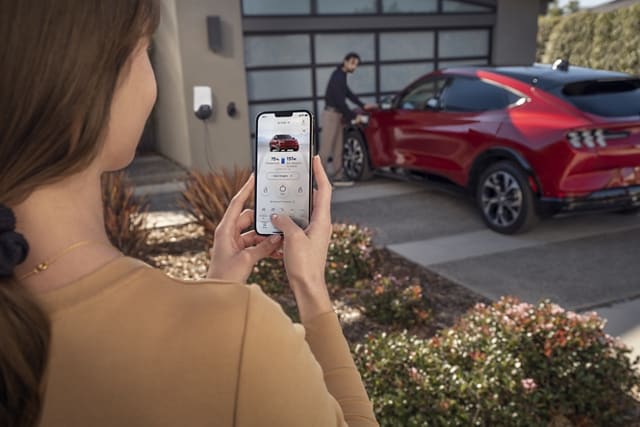 Woman using the FordPass App to remotely control her 2023 Ford Mustang Mach-E®