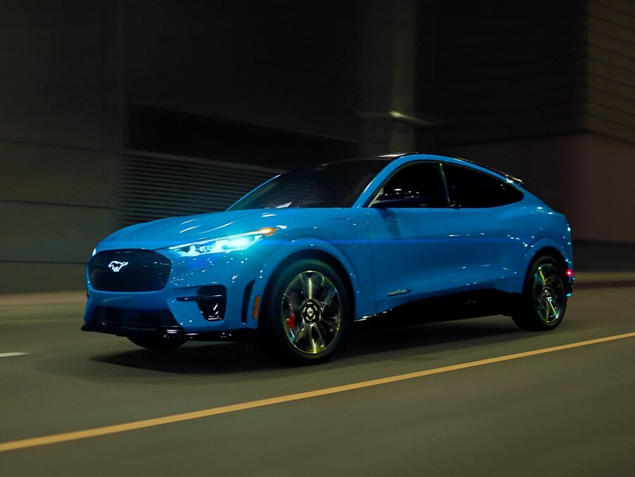 A 2023 Ford Mustang Mach-E GT being driven on a street at night