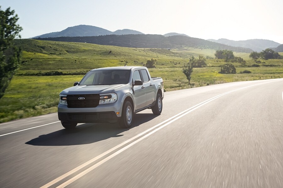 A 2023 Ford Maverick® truck on a country highway with hills in the background