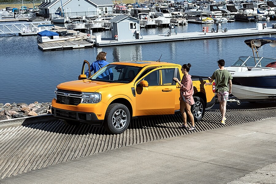 Cyber Orange 2023 Ford Maverick® truck with available 4K tow package prepares to launch a boat into the water