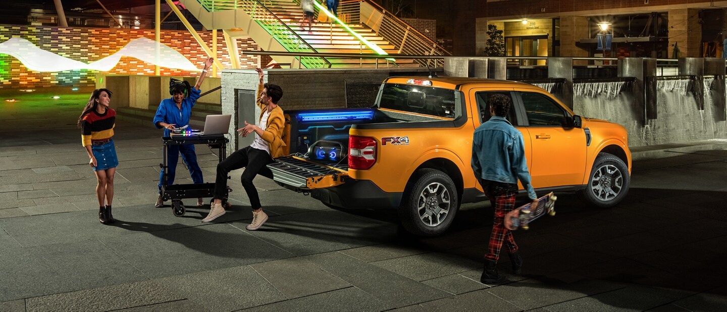 Two people and a DJ having a party with their Cyber Orange 2023 Ford Maverick® Truck"
