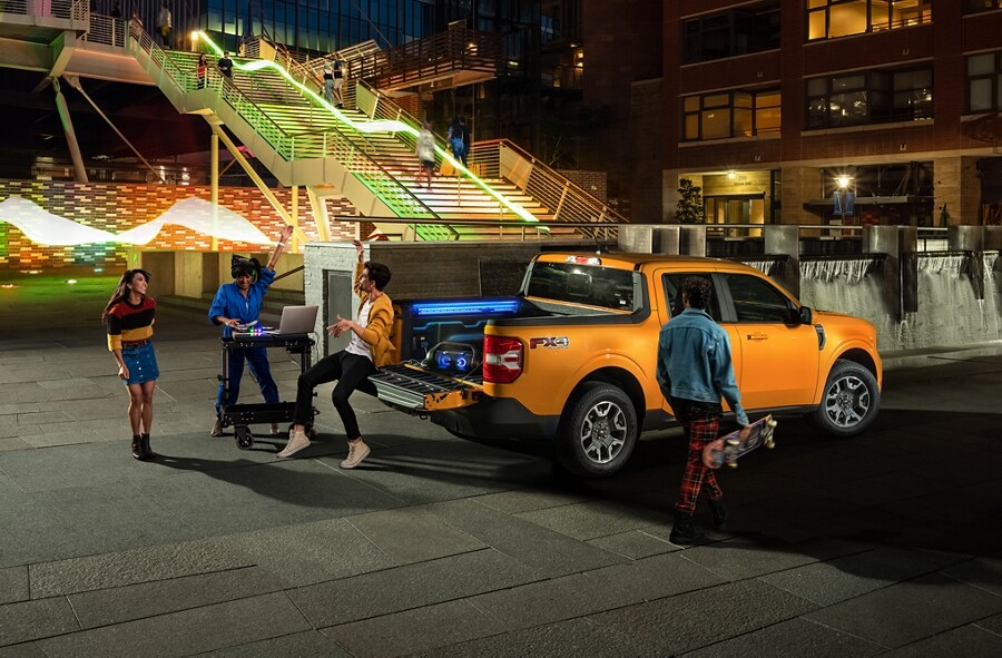 Two people and a DJ having a party with their Cyber Orange 2023 Ford Maverick® Truck"