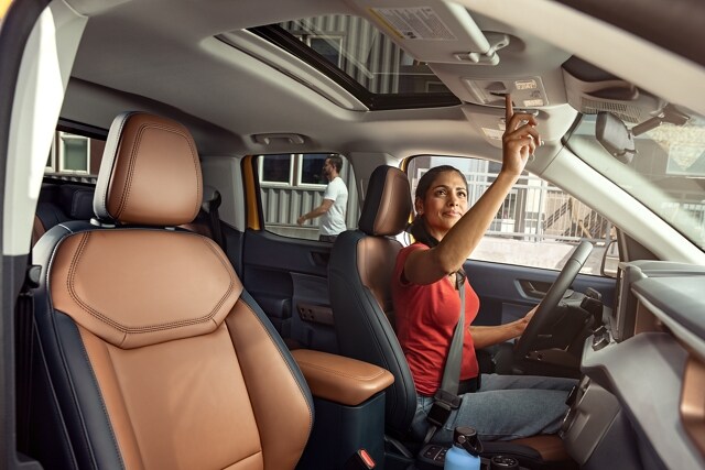 Woman operating the power moonroof inside the 2023 Ford Maverick® LARIAT model