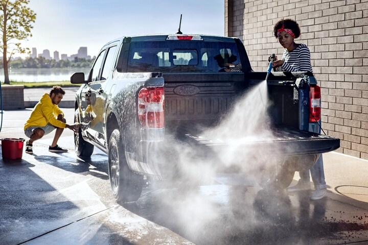 2023 Ford Maverick® truck in the color Area 51 being hosed down and scrubbed by two people