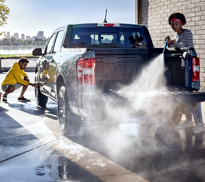 2023 Ford Maverick® truck in the color Area 51 being hosed down and scrubbed by two people