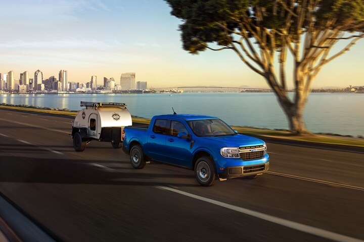 2023 Ford Maverick® LARIAT model with available 4K Tow Package hauls a trailer away from the city