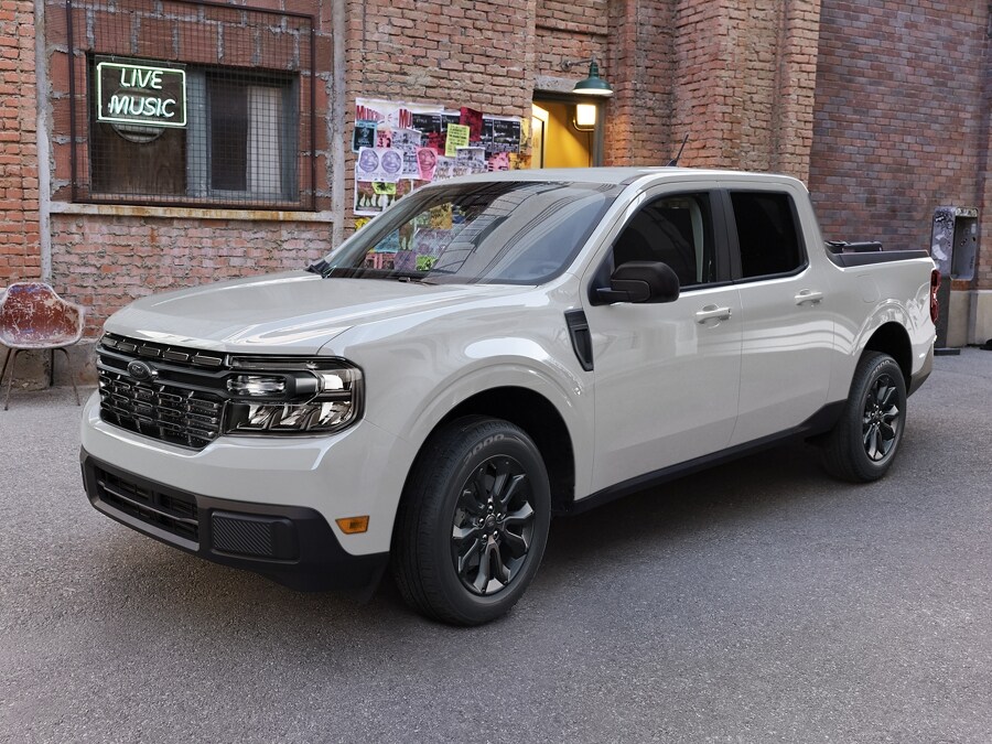 2024 creamy white Ford Maverick black appearance package parked in front of vinyl music shop