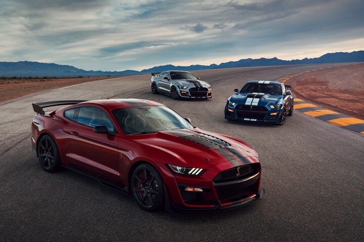 Three 2021 Ford Mustang G T 500s staggered on a road in the desert