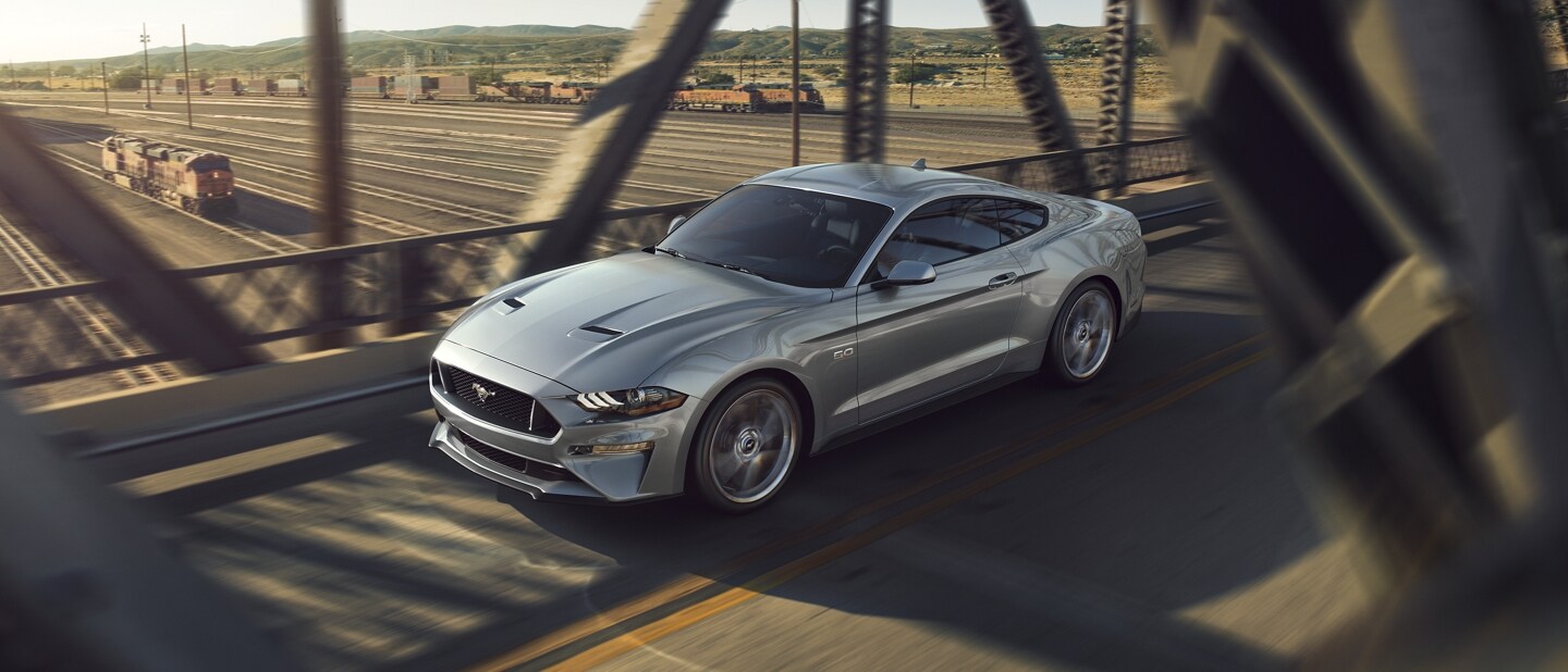 Ford Mustang® 2023 cupé en Iconic Silver Metallic cruzando un puente