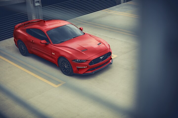 Una Ford Mustang® Coupe 2023 estacionada afuera de un garaje