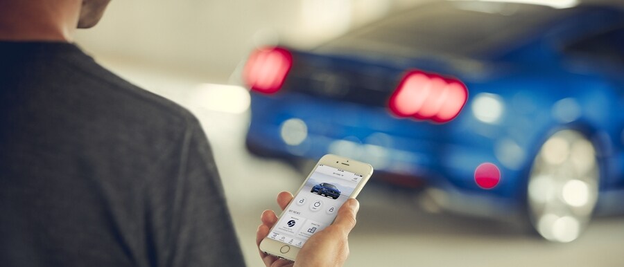 Una persona opera su teléfono para arrancar tu Ford Mustang® 2023 cupé