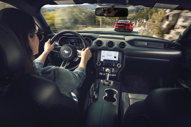 Person driving a 2023 Ford Mustang® coupe down a mountainous road