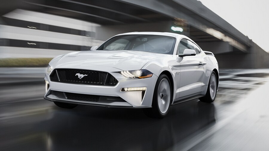 2023 Ford Mustang® coupe in Oxford White being driven down a street