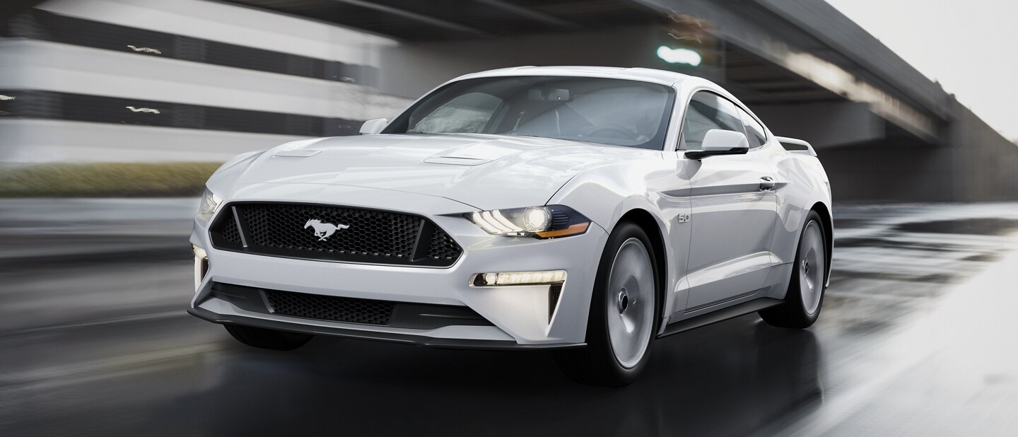 Una Ford Mustang® Coupe 2023 en Oxford White circulando por una calle