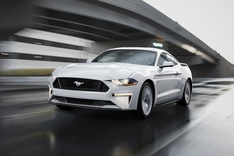 2023 Ford Mustang® coupe in Oxford White being driven down a street