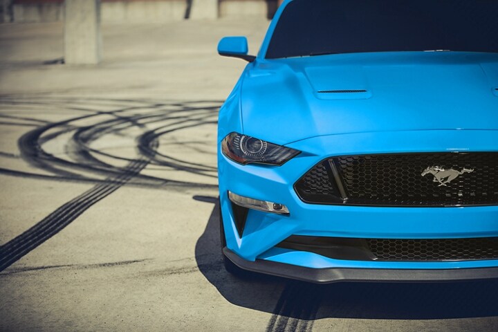 Una Ford Mustang® Coupe 2023 estacionada con marcas de desgaste en el fondo