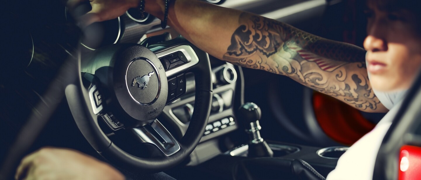 Persona en el asiento del conductor de un Ford Mustang® 2023 cupé