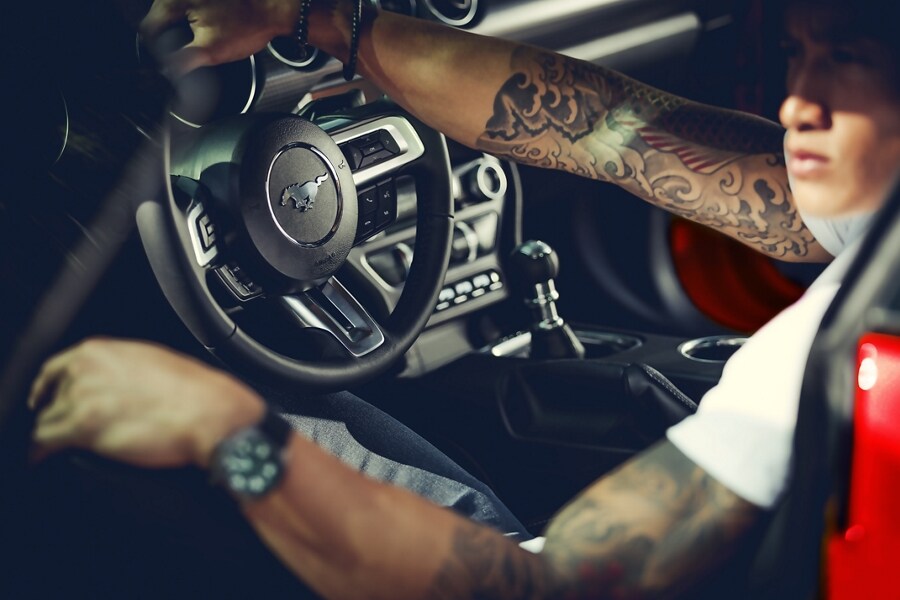 A person in the driver’s seat of a 2023 Ford Mustang® coupe