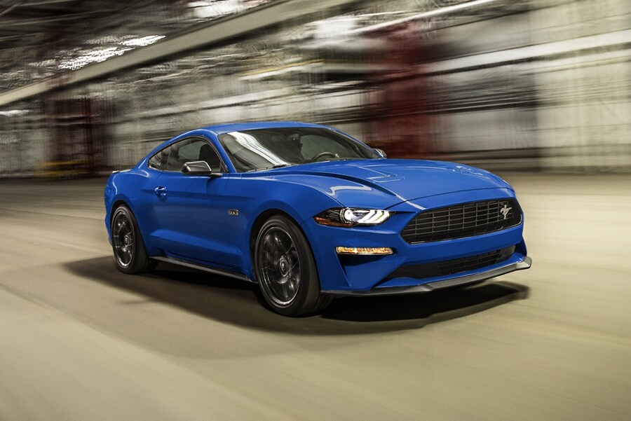 A 2023 Ford Mustang® coupe being driven through a parking structure with a blurred background