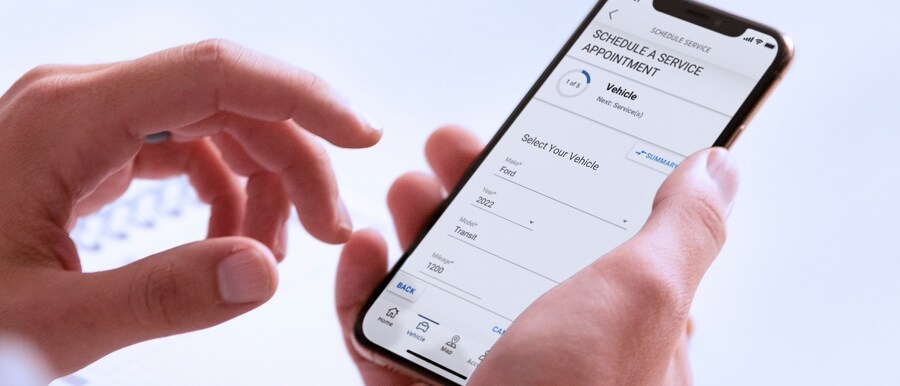 Un hombre sosteniendo un smartphone que muestra la Aplicación FordPass™