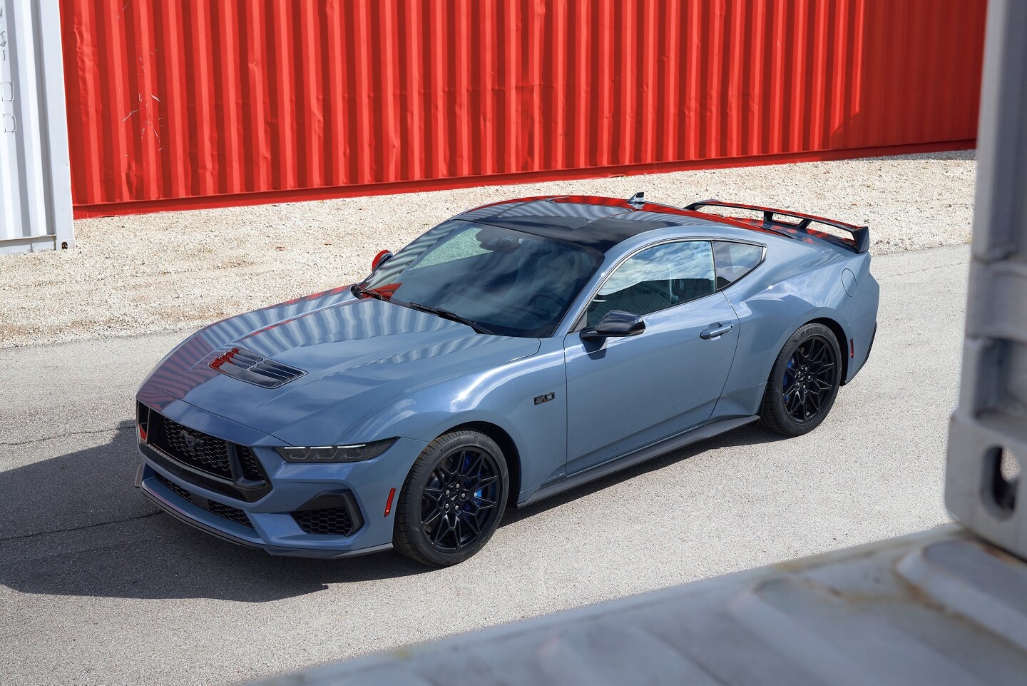 2024 Ford Mustang® GT coupe with Mustang Nite Pony Package parked near shipping containers