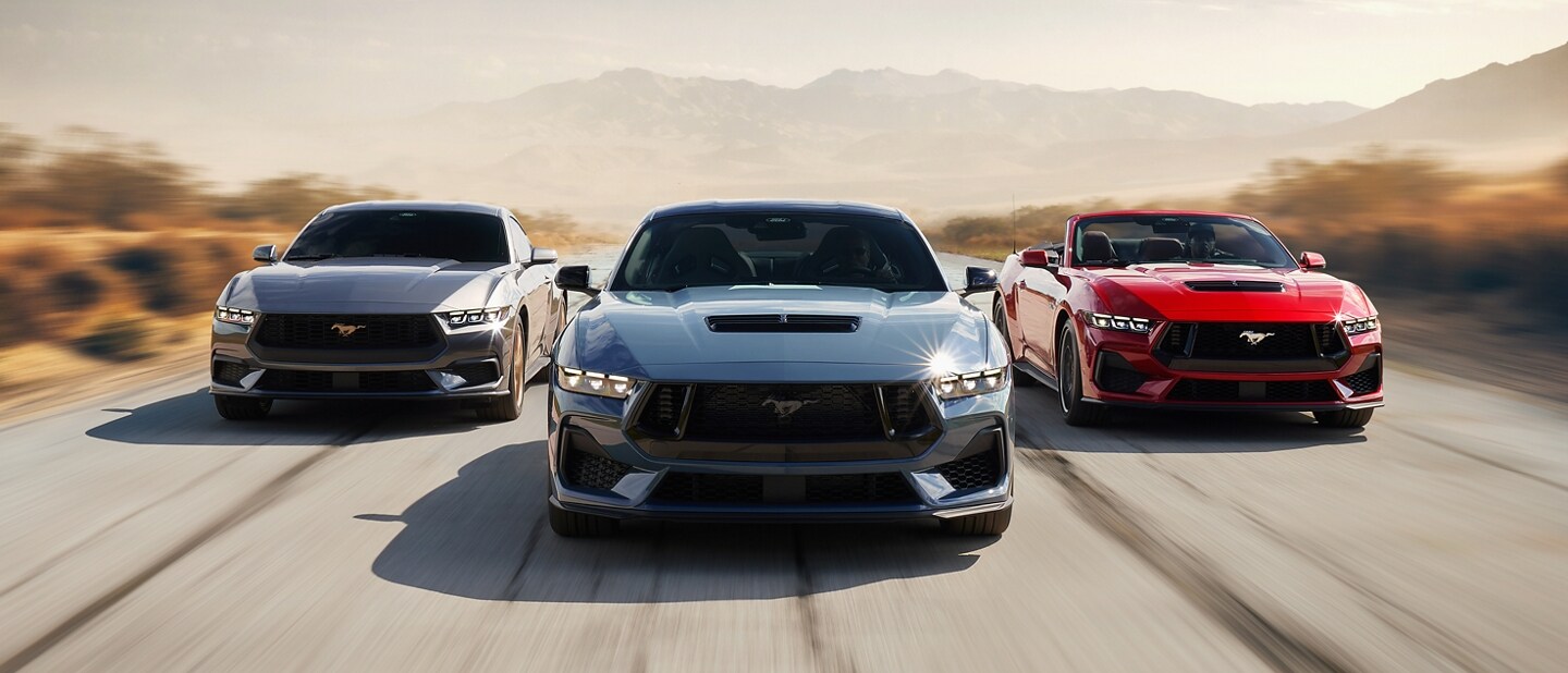 Three 2024 Ford Mustang® vehicles being driven on a desert road