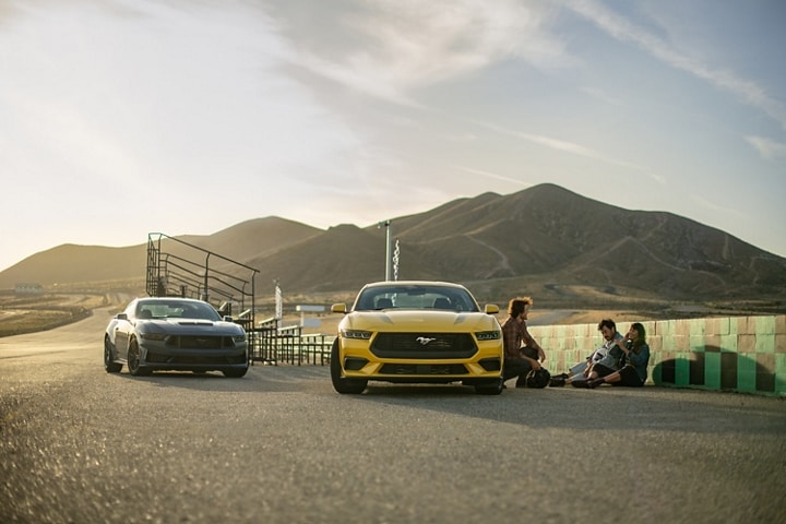 2024 Ford Mustang® EcoBoost® coupe in Yellow Splash Metallic Tri-coat parked near people