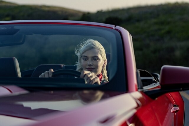 Person driving a 2024 Ford Mustang® convertible model on a highway