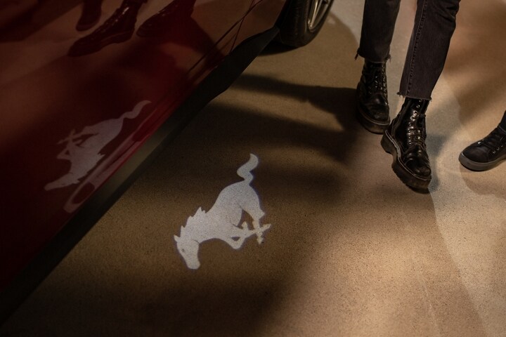 People approaching a 2024 Ford Mustang® GT Premium model with approach detection welcome exterior lighting