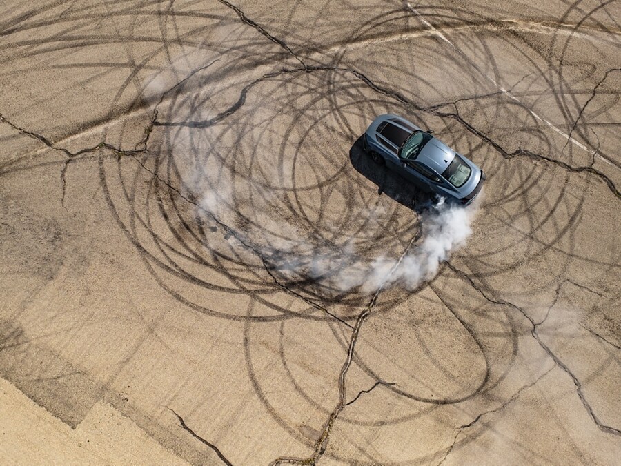 2024 Ford Mustang® coupe with stripes and a driver performing burnouts on a closed course