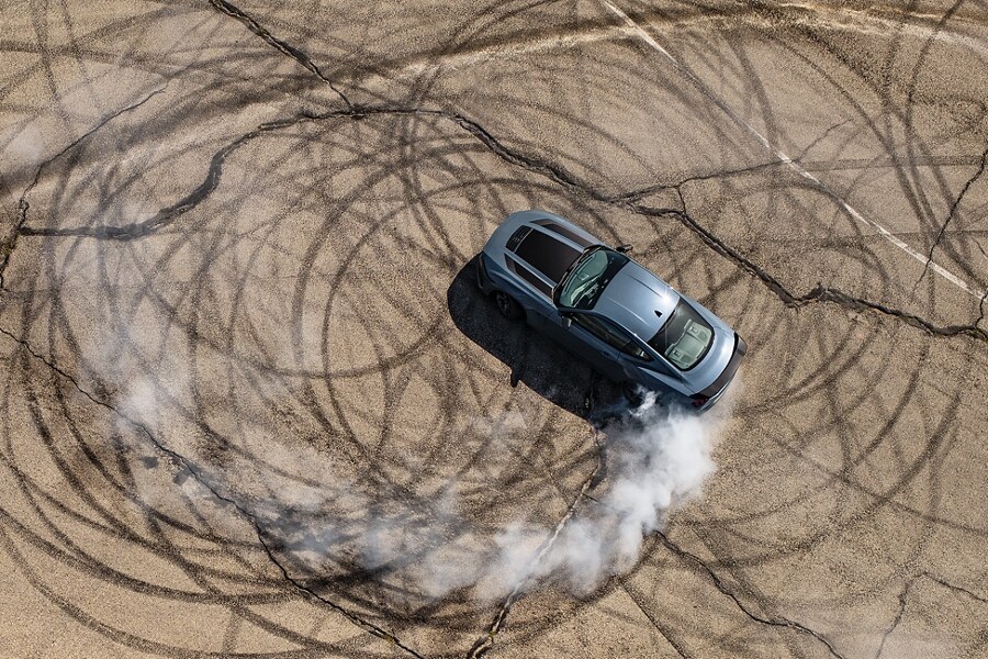2024 Ford Mustang® coupe with stripes and a driver performing burnouts on a closed course