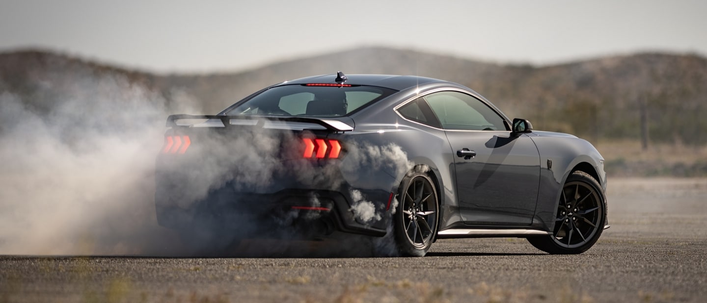 Driver performing a burnout on a closed course in a 2024 Ford Mustang® Dark Horse™ coupe