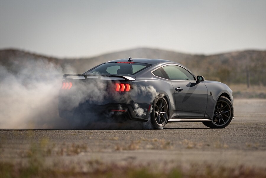 Driver performing a burnout on a closed course in a 2024 Ford Mustang® Dark Horse™ model