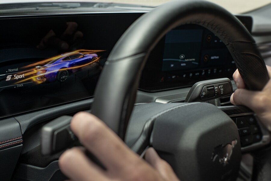Person driving a 2024 Ford Mustang® model with a view of the cockpit screens