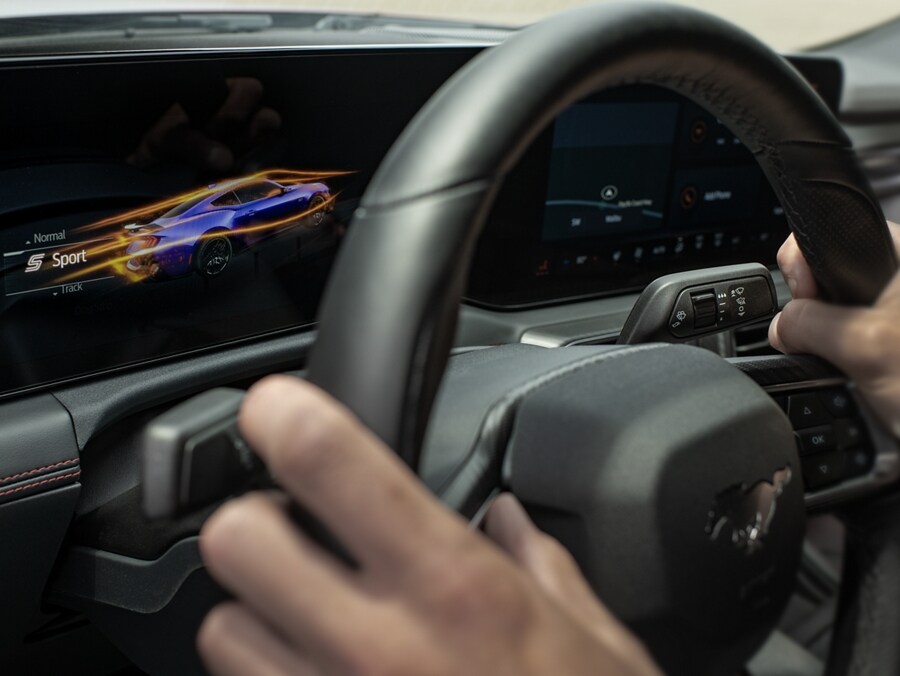Person driving a 2024 Mustang® coupe with a view of the cockpit screens