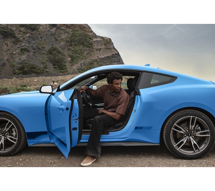 Person exiting a 2024 Ford Mustang® coupe parked in the desert