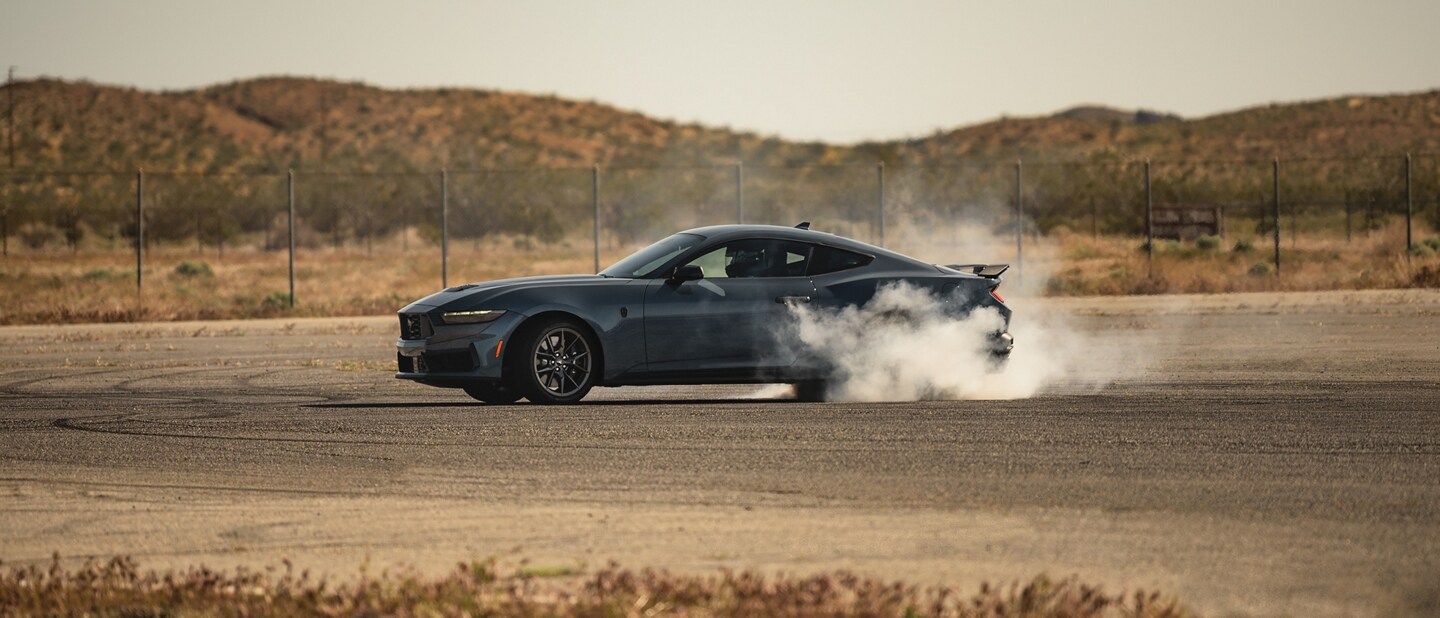 2024 Ford Mustang® Dark Horse™ coupe with a driver performing burnouts on a closed course